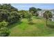 Lush green lawn surrounded by mature trees, next to a multi-story building at 2460 Persian Dr # 54, Clearwater, FL 33763