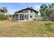 Image of a house's backyard showing a screened-in porch and mature landscaping at 2493 6Th Sw Ave, Largo, FL 33770
