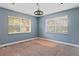 Bedroom features two windows with blinds, a ceiling lamp, and blue walls at 2493 6Th Sw Ave, Largo, FL 33770
