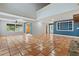 Spacious living room featuring terracotta tile flooring, multiple windows, and blue accent wall at 2493 6Th Sw Ave, Largo, FL 33770