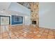 Bright living room featuring terracotta tile flooring, a stone fireplace, and blue accent wall at 2493 6Th Sw Ave, Largo, FL 33770