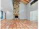 Spacious living room featuring terracotta tile flooring, a stone fireplace, and high ceilings at 2493 6Th Sw Ave, Largo, FL 33770