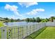 A peaceful backyard with a fence, lush green grass, and a picturesque view of a serene lake at 25330 Conestoga Dr, Land O Lakes, FL 34639