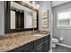 Well-lit bathroom featuring a vanity with granite counters, framed mirror, and toilet with decor art at 25330 Conestoga Dr, Land O Lakes, FL 34639