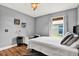 Cozy bedroom with wood floors, and a window for natural light, decorated with paintings and a ceiling fan at 25330 Conestoga Dr, Land O Lakes, FL 34639