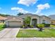 Charming home with a well-manicured lawn, mature landscaping, and a spacious two-car garage at 25330 Conestoga Dr, Land O Lakes, FL 34639