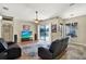 Bright living room with ceiling fan, leather seating, and sliding glass doors to the pool at 25330 Conestoga Dr, Land O Lakes, FL 34639