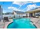 Relaxing screened-in pool area with lounge chairs, outdoor dining, and a beautiful pool at 25330 Conestoga Dr, Land O Lakes, FL 34639