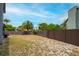 Large, partially-shaded backyard featuring a mature palm tree and privacy fence, perfect for outdoor activities at 3177 Montrose Pl, Palm Harbor, FL 34684