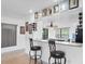 View of kitchen bar with granite countertops and seating; decorated with pictures and wine rack at 3177 Montrose Pl, Palm Harbor, FL 34684