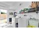 Bright laundry room with washer, dryer, utility sink, water heater and access to the backyard at 3177 Montrose Pl, Palm Harbor, FL 34684