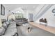 Inviting living room featuring high ceilings, abundant natural light, a staircase, and stylish furnishings at 3177 Montrose Pl, Palm Harbor, FL 34684