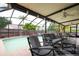 This screened patio with a ceiling fan offers ample seating and views of the backyard and sparkling pool at 3177 Montrose Pl, Palm Harbor, FL 34684