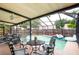 Relax in this screened pool area with dining and lounge seating, perfect for entertaining and enjoying outdoor living at 3177 Montrose Pl, Palm Harbor, FL 34684