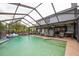 This spacious pool area features a covered patio with grilling station, dining area, and direct access to the home at 3177 Montrose Pl, Palm Harbor, FL 34684