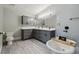 Bathroom with gray cabinets, double vanity, and soaking tub with matte black fixtures at 3238 Cullendale Dr, Tampa, FL 33618