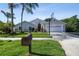 Inviting home exterior featuring a manicured lawn, palm trees, and a basketball hoop at 3238 Cullendale Dr, Tampa, FL 33618