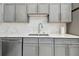 Kitchen detail showcasing marble countertops, stainless steel appliances and gray cabinets at 3238 Cullendale Dr, Tampa, FL 33618