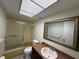 Bathroom with tub and shower combo, granite vanity, and light-filled skylight at 3411 Teeside Dr, New Port Richey, FL 34655