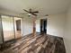 Spacious bedroom with wood floors, ceiling fan, and sliding glass door to patio at 3411 Teeside Dr, New Port Richey, FL 34655