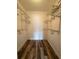 Walk-in closet featuring built-in shelving and wood-look flooring at 3411 Teeside Dr, New Port Richey, FL 34655