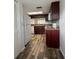 Galley kitchen with wood-look flooring, granite counters, and white appliances at 3411 Teeside Dr, New Port Richey, FL 34655