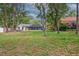 This backyard is spacious with a screened-in porch, grass, and wooded areas at 3906 Floyd Rd, Tampa, FL 33618