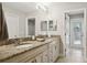 Bathroom featuring double sinks, granite counters, and access to the backyard at 3906 Floyd Rd, Tampa, FL 33618