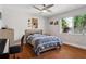 Well-lit bedroom featuring hardwood floors, a ceiling fan, and a large window with green foliage at 3906 Floyd Rd, Tampa, FL 33618