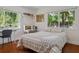 Bright bedroom with hardwood floors, desk, and a large window with a view of lush greenery at 3906 Floyd Rd, Tampa, FL 33618