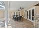 This covered patio has a table, chairs, ceiling fans, an outdoor kitchen, and overlooks the pool at 3906 Floyd Rd, Tampa, FL 33618