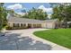 Inviting single-story home with mature trees, a large driveway, and a well-manicured lawn at 3906 Floyd Rd, Tampa, FL 33618