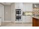 Kitchen featuring double ovens, stainless steel appliances, and custom cabinetry at 3906 Floyd Rd, Tampa, FL 33618