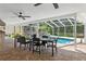 Enclosed outdoor dining area with view of waterfall pool and backyard at 3906 Floyd Rd, Tampa, FL 33618