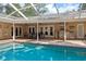 This screened-in pool is situated next to the outdoor kitchen and covered patio seating area at 3906 Floyd Rd, Tampa, FL 33618