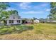 Large, grassy backyard with a view of the two-story house and detached garage at 4012 Woodacre Ln, Tampa, FL 33624