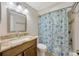 Bright bathroom featuring a granite vanity top, modern sink and a shower with patterned curtain at 4012 Woodacre Ln, Tampa, FL 33624