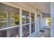Bright porch with large windows next to front door and classic wall mounted lamp at 4012 Woodacre Ln, Tampa, FL 33624