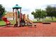 Community playground featuring a slide, stairs, and red rubber mulch for safety and fun at 4074 Parkway Blvd, Land O Lakes, FL 34639