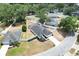Aerial view of suburban home featuring a pool and fenced yard surrounded by lush trees and green spaces at 4302 Longfellow Dr, Plant City, FL 33566