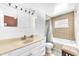 Bright bathroom featuring a vanity with storage, and bathtub with tile surround at 4302 Longfellow Dr, Plant City, FL 33566
