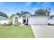 Attractive single-Gathering home featuring a well-kept lawn, garden beds, a driveway leading to a two-car garage at 4302 Longfellow Dr, Plant City, FL 33566
