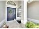 Close-up of the front door, adorned with a festive wreath and surrounded by decorative plants at 4302 Longfellow Dr, Plant City, FL 33566
