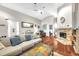 Bright living room with a vaulted ceiling, fireplace, hardwood flooring, and comfortable, neutral-toned furniture at 4302 Longfellow Dr, Plant City, FL 33566