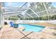 Screened-in pool area with lounge chair, table, and spacious brick paver deck at 4302 Longfellow Dr, Plant City, FL 33566