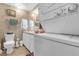A bathroom with stacked washer and dryer, toilet, vanity, mirror, and earth-toned walls at 4314 12Th Street E Ct, Ellenton, FL 34222