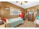 Bedroom with wood paneling and a bed, creating a cozy, vintage-inspired space at 4314 12Th Street E Ct, Ellenton, FL 34222