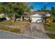 Traditional-style home boasting a two-car garage, brick accents, and a well-manicured front yard at 5036 Glenhurst Ln, New Port Richey, FL 34653
