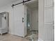 Hallway featuring neutral paint, storage cabinets, and a decorative sliding barn door at 5036 Glenhurst Ln, New Port Richey, FL 34653