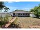 Backyard featuring well-kept lawn, garden beds, a charming pathway and a covered patio extending from the house at 5081 72Nd N Ave, Pinellas Park, FL 33781